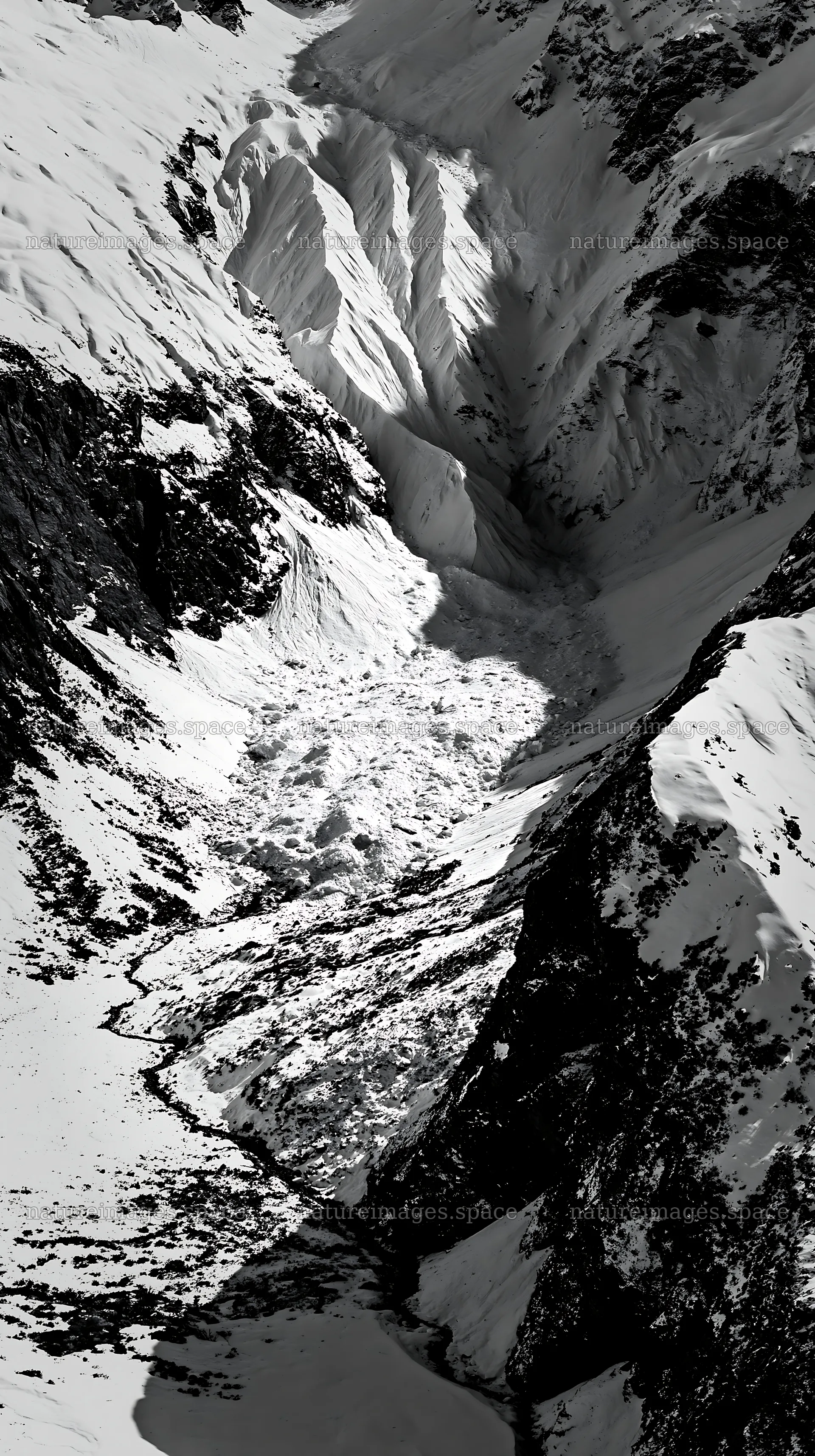 Snowy meadow valley with a glacier in aerial view – nature images 5938x10608