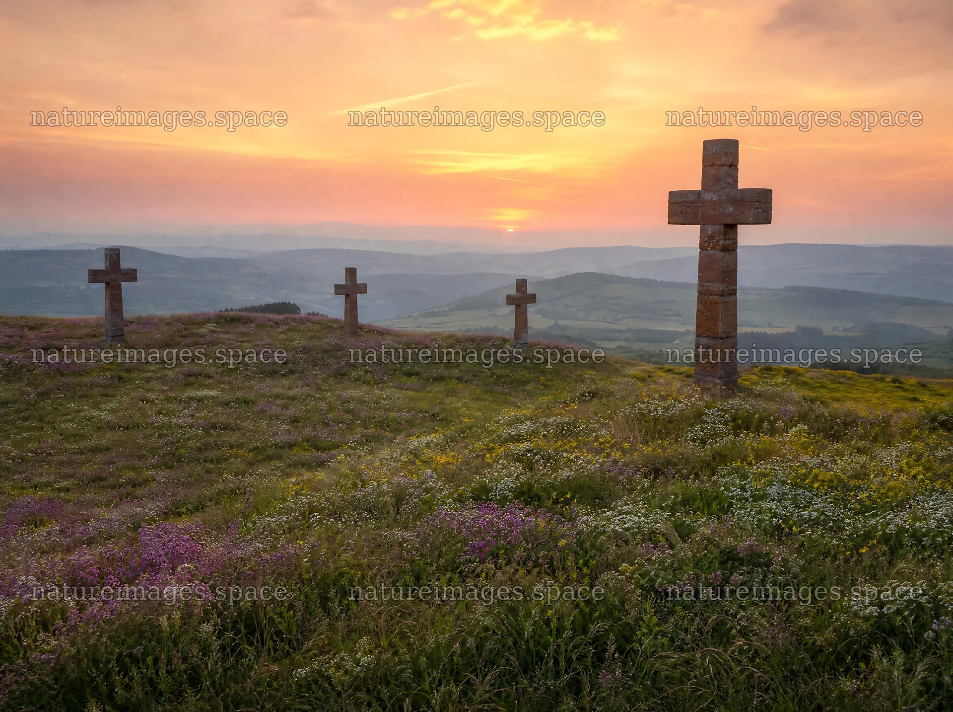 Christian crosses on meadow at sunrise with sky and light rays – nature images 9186x6858