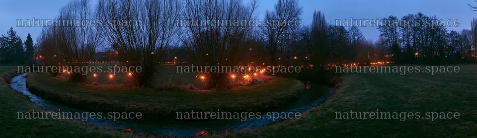 Christmas lights by stream in meadow at dusk – nature images 14762x4268