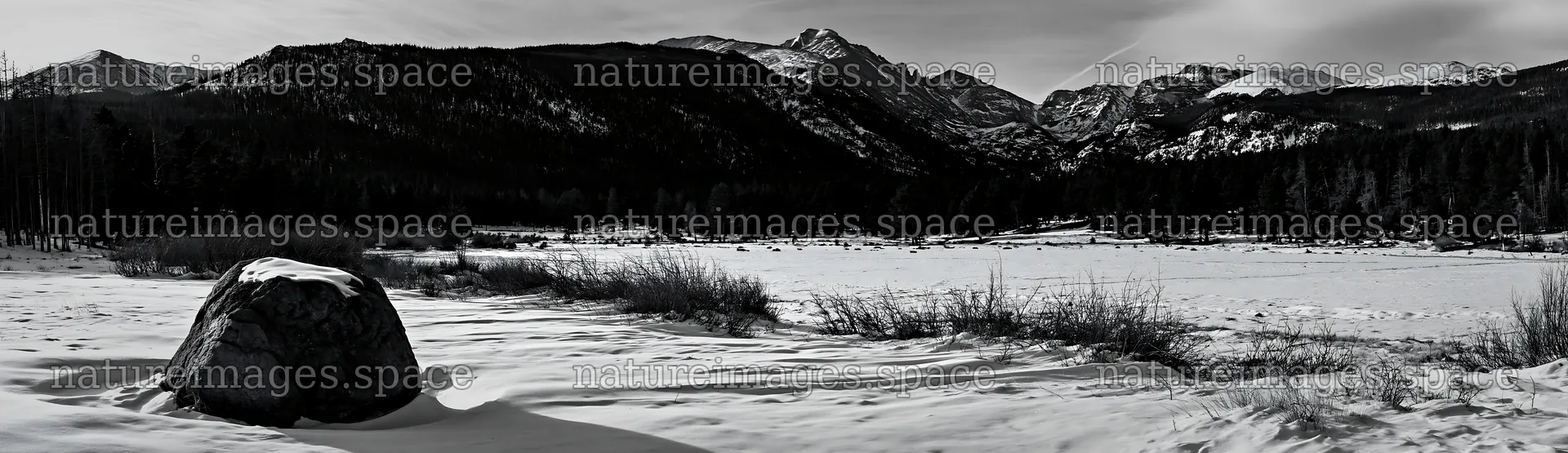 Snowy Rocky Mountain Park meadow with a large boulder – nature images 14762x4268