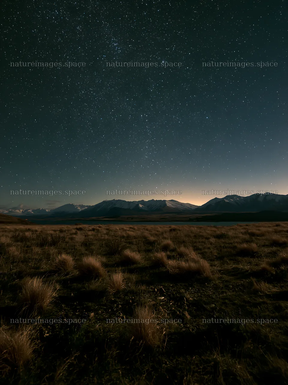 Night sky over Lake Tekapo with snowy alps in the background – nature images 6866x9174