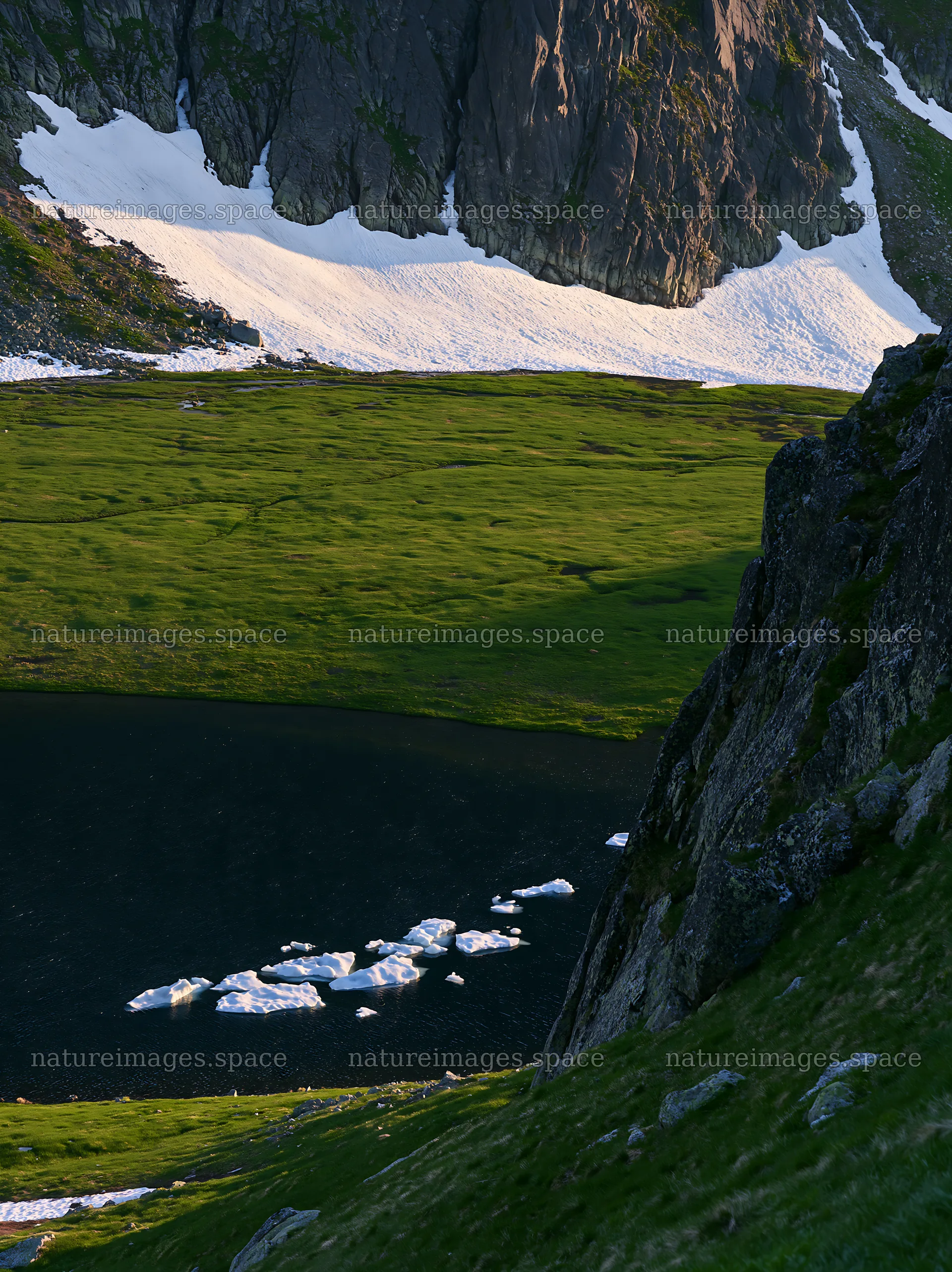 Spring snowmelt in Tatra mountains meadow with dark pond – nature images 6866x9174